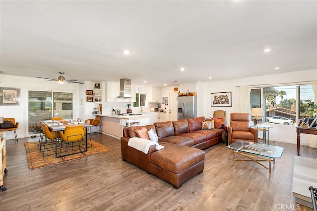 living room with ceiling fan and light hardwood / wood-style floors