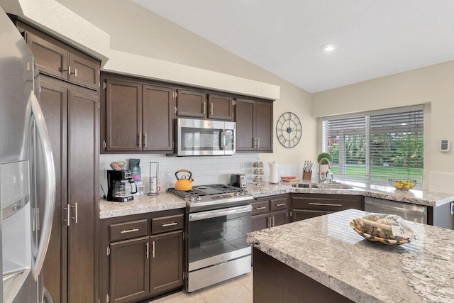 kitchen with dark brown cabinets, stainless steel appliances, lofted ceiling, and sink