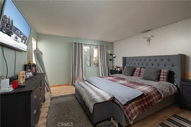 bedroom featuring a textured ceiling and light hardwood / wood-style floors