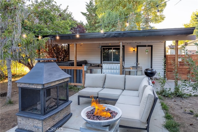 view of patio featuring an outdoor living space with a fire pit