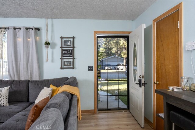 doorway featuring a textured ceiling and light hardwood / wood-style floors