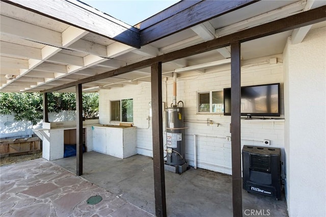 view of patio / terrace featuring heating unit, exterior kitchen, and gas water heater