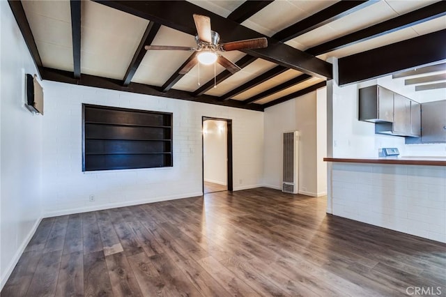 unfurnished living room with ceiling fan, dark hardwood / wood-style flooring, and beamed ceiling