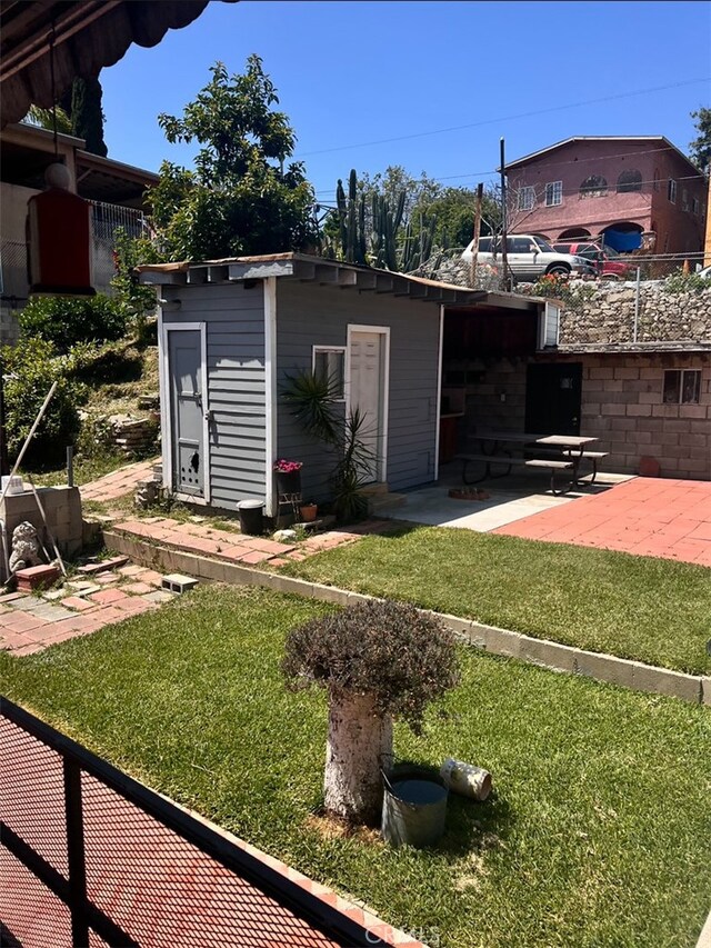 view of yard with an outdoor structure and a patio area