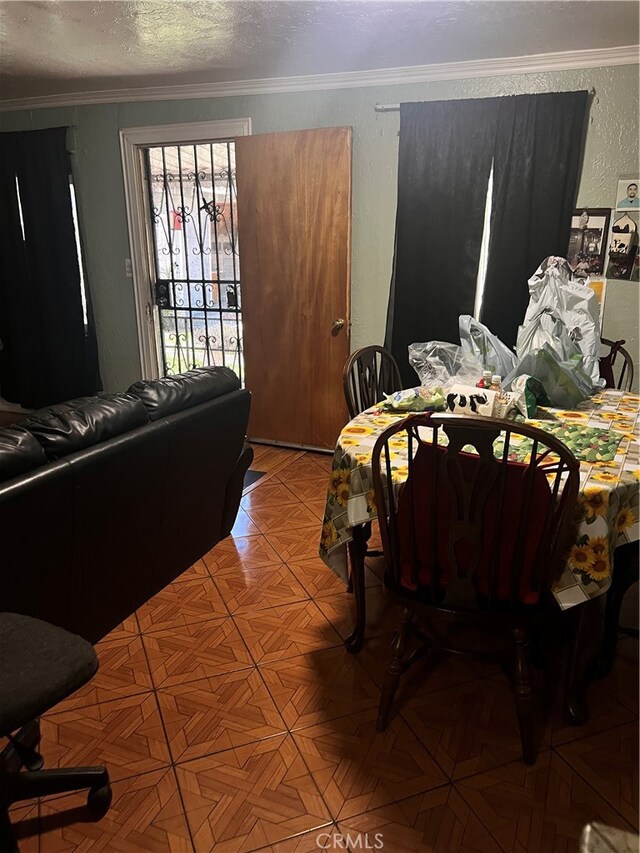 dining area with a textured ceiling and crown molding