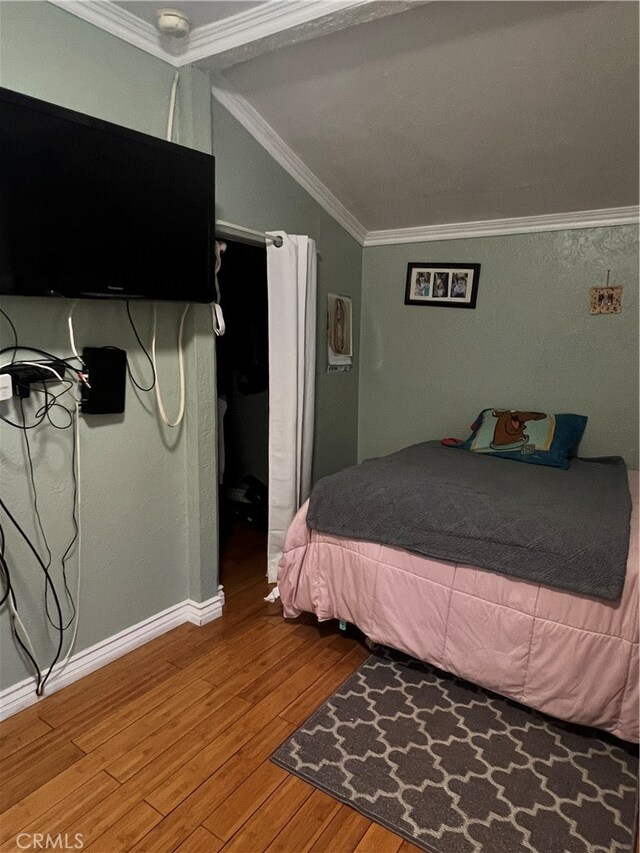 bedroom featuring ornamental molding and hardwood / wood-style floors