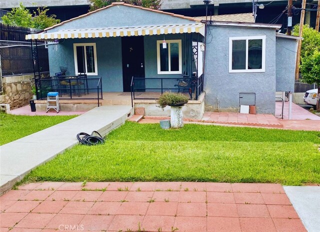 view of front of home featuring a front lawn and a patio area