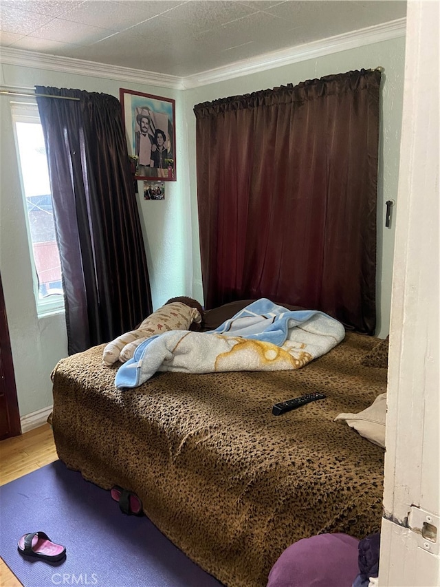 bedroom featuring ornamental molding and hardwood / wood-style flooring