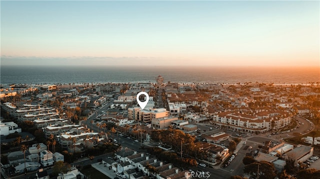 aerial view at dusk featuring a water view