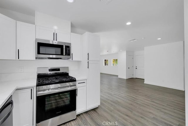 kitchen with white cabinets, light wood-style floors, stainless steel appliances, and light countertops