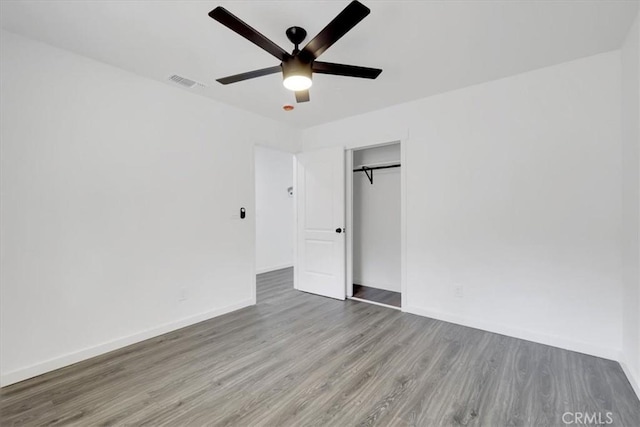 unfurnished bedroom with baseboards, visible vents, ceiling fan, light wood-style floors, and a closet