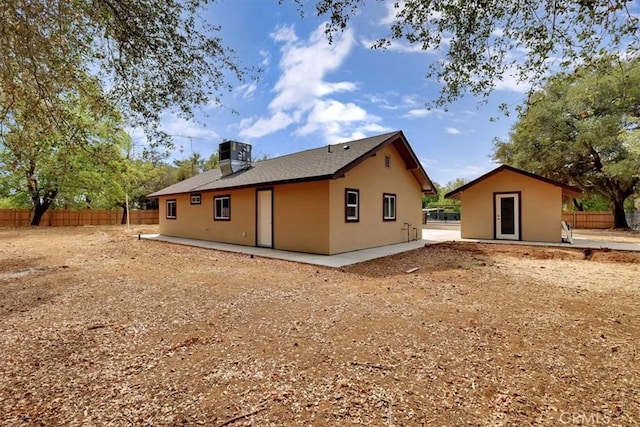 rear view of property with fence and stucco siding