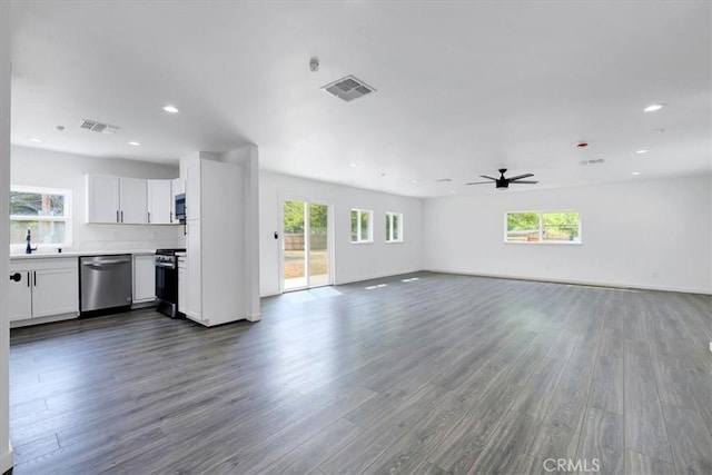 unfurnished living room with plenty of natural light, wood finished floors, and visible vents