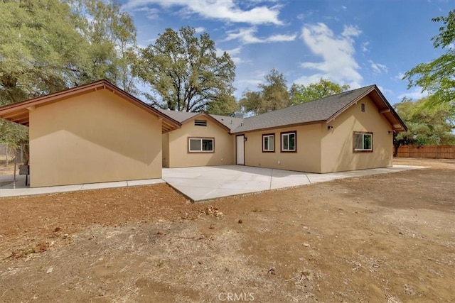 back of property with a patio, fence, and stucco siding