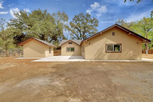 back of house with a patio, fence, and stucco siding