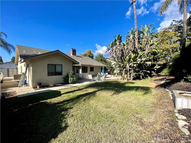 rear view of property with a patio area and a yard