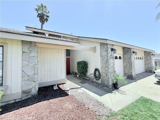 1732 Winston Ave, Upland, CA 91784 - doorway to property with stone siding, driveway, and an attached garage