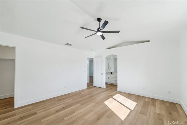 unfurnished bedroom featuring ceiling fan, light hardwood / wood-style floors, a closet, and ensuite bath