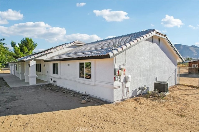 view of home's exterior with a patio area, cooling unit, and a mountain view