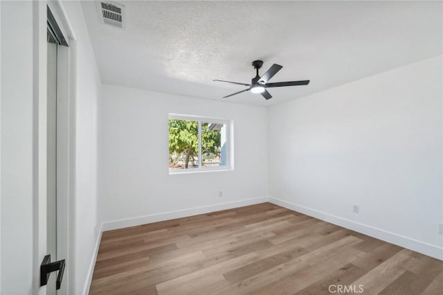 spare room with ceiling fan, light hardwood / wood-style flooring, and a textured ceiling