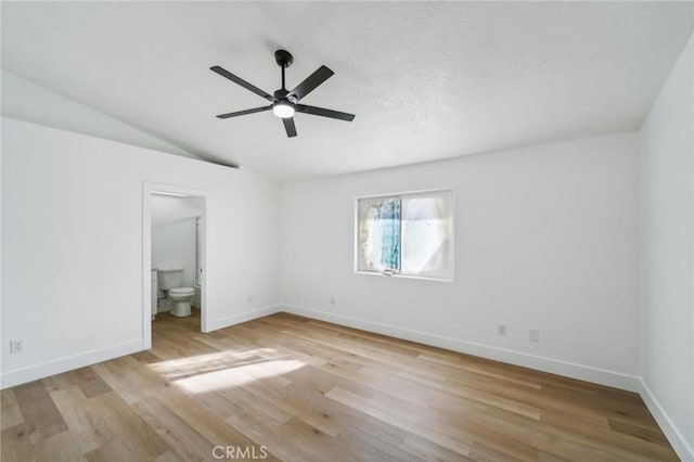 unfurnished bedroom featuring lofted ceiling, light wood-type flooring, connected bathroom, and ceiling fan