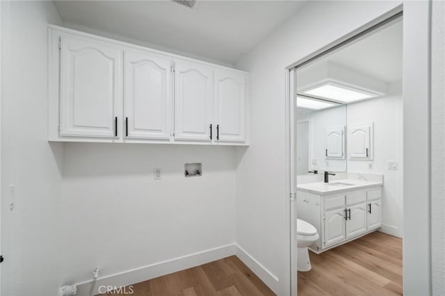 laundry area with sink, hookup for a washing machine, light hardwood / wood-style flooring, and gas dryer hookup