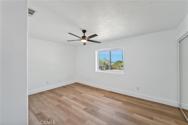 spare room featuring light hardwood / wood-style floors, a textured ceiling, and ceiling fan