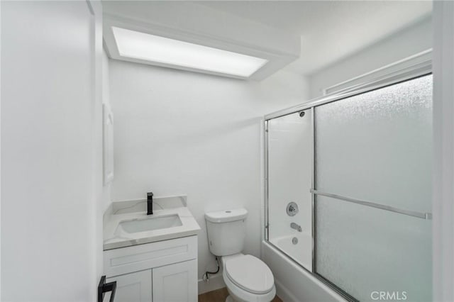 full bathroom with bath / shower combo with glass door, toilet, and vanity