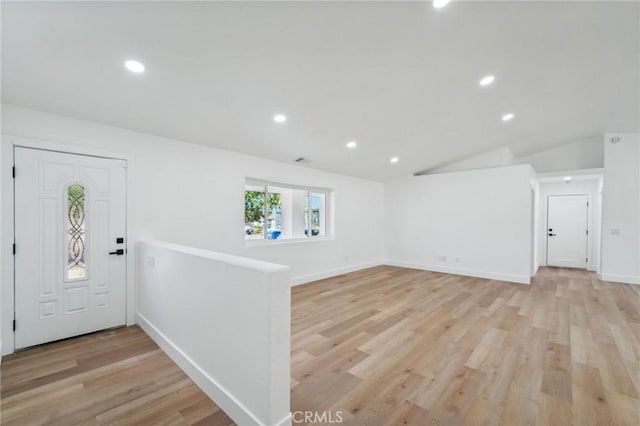 foyer entrance featuring light hardwood / wood-style flooring and lofted ceiling