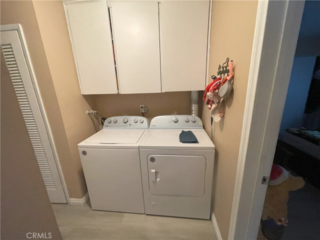 clothes washing area featuring cabinets and independent washer and dryer