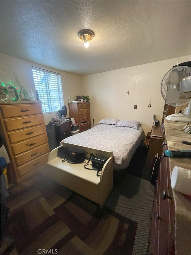 bedroom with carpet floors and a textured ceiling