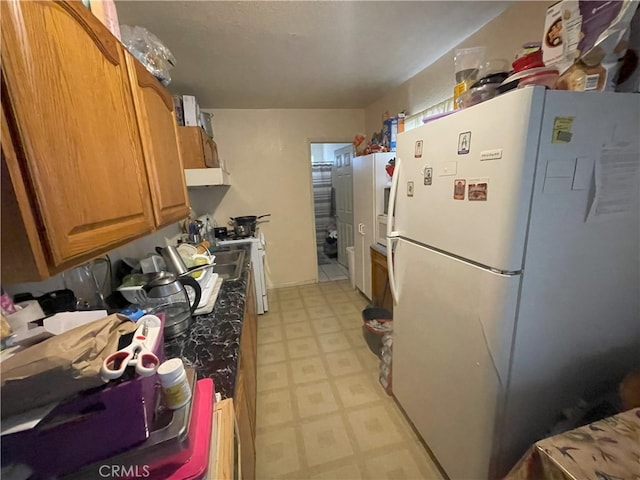 kitchen with white refrigerator and exhaust hood