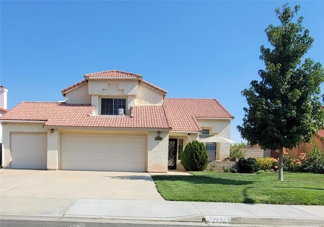 mediterranean / spanish house with a front yard and a garage