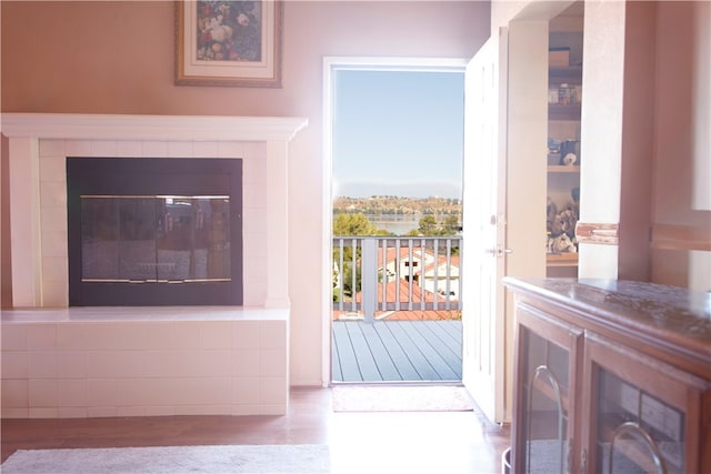 doorway with light hardwood / wood-style flooring and a tile fireplace