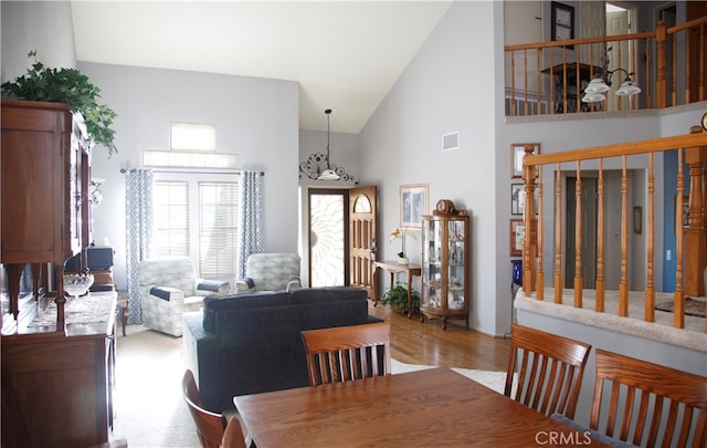 dining area featuring high vaulted ceiling and light wood-type flooring