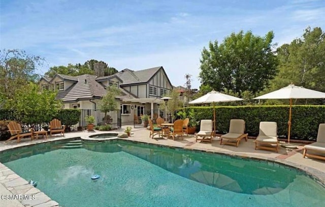 view of pool featuring a patio area and an in ground hot tub