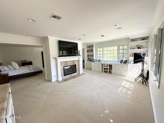 unfurnished living room featuring light carpet, ornamental molding, built in desk, and a tiled fireplace