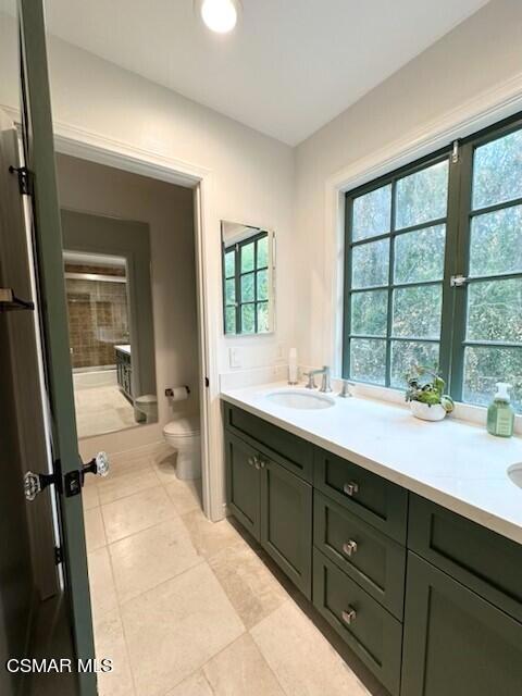 bathroom featuring toilet, tile patterned floors, and vanity