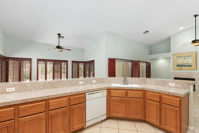 kitchen with dishwasher, a tiled fireplace, ceiling fan, and sink