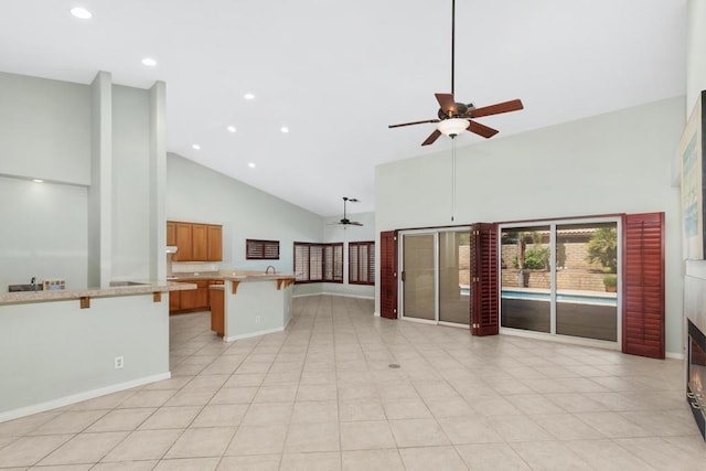 unfurnished living room featuring light tile patterned floors, high vaulted ceiling, and ceiling fan