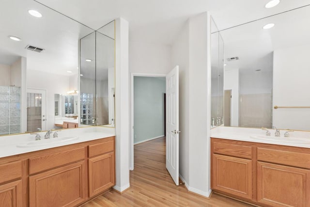 bathroom featuring a shower, vanity, and hardwood / wood-style flooring