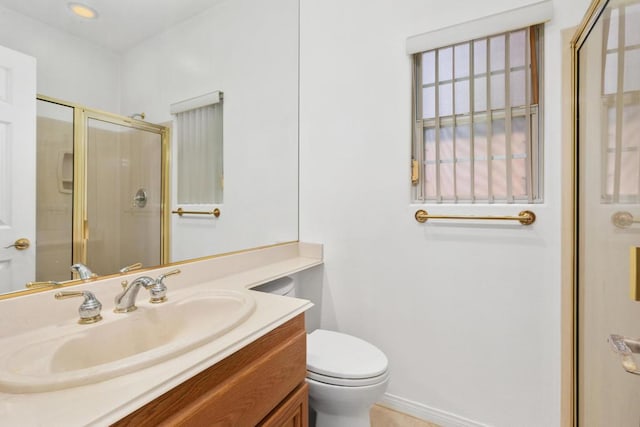 bathroom with toilet, vanity, and walk in shower