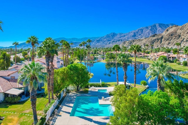 view of pool with a patio area and a water and mountain view