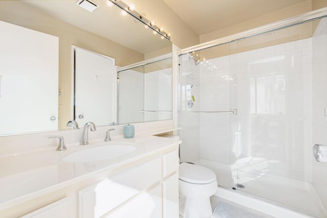 bathroom with an enclosed shower, vanity, and toilet