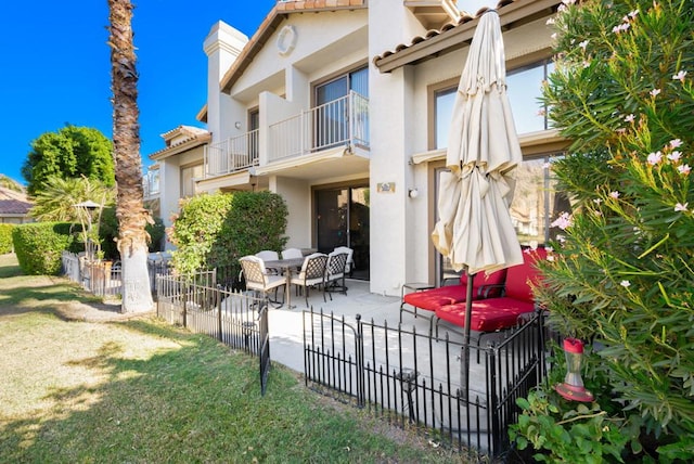 back of property with a balcony and a patio area