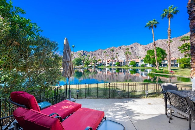 view of patio / terrace featuring a water and mountain view