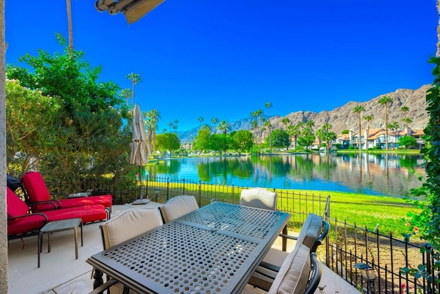 view of patio / terrace with a water and mountain view