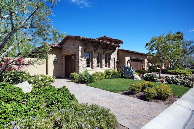 mediterranean / spanish house featuring a front yard and a garage