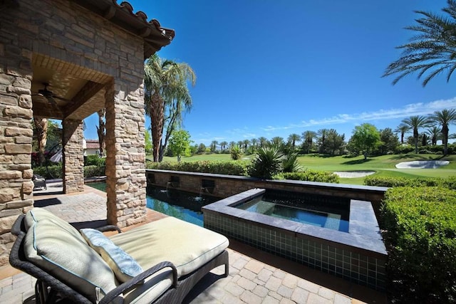 view of patio featuring ceiling fan and a swimming pool with hot tub