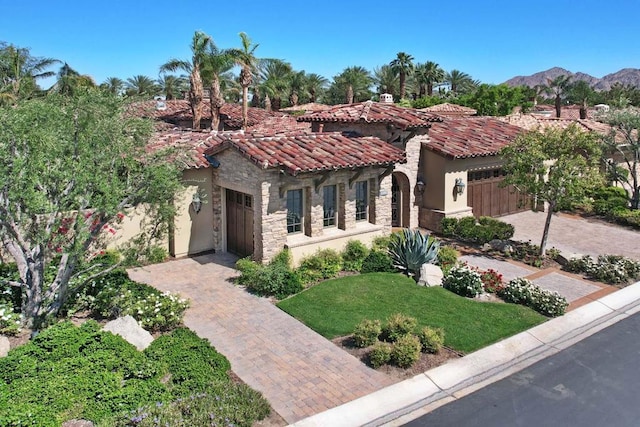 mediterranean / spanish house with a mountain view, a garage, and a front yard